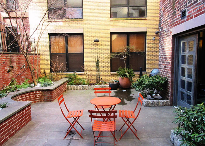 Photo of an outdoor patio area with a brick sitting area.